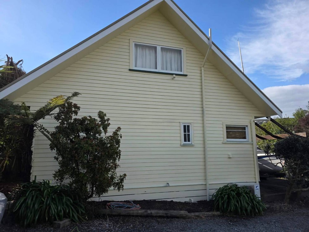 The same cream gable repainted, clean under a blue sky