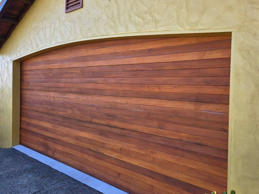 The same timber garage door finished in a rich, even brown stain